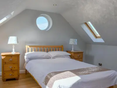 a bedroom with a bed and two night stands with lamps at Hill Farm Cottage in Stretham