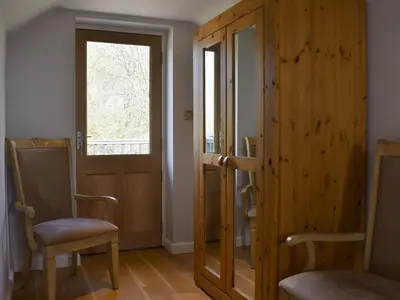 a room with a door and two chairs and a window at Hill Farm Cottage in Stretham