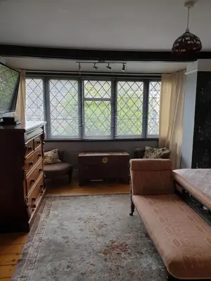 a living room with windows and a couch at Harry's bed and breakfast in Cambridge