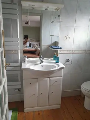 a bathroom with a sink and a toilet and a mirror at Harry's bed and breakfast in Cambridge