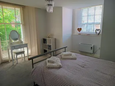 a bedroom with a bed and a mirror and a sink at Luxury 2-Bed Flat Central Ipswich Parking in Ipswich