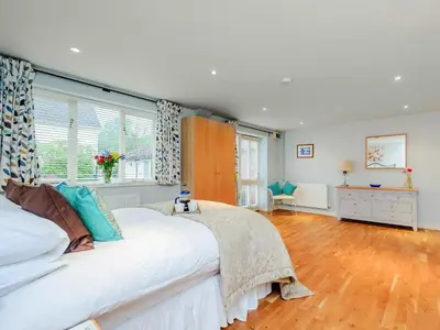 a bedroom with a large white bed and a window at Coachman's Cottage - Uk11449 in Mellis