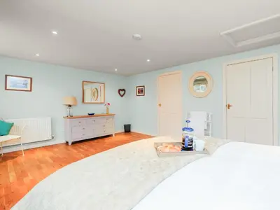 a bedroom with a large white bed and a table at Coachman's Cottage - Uk11449 in Mellis
