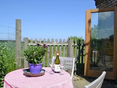 a table with a bottle of wine and a potted plant at The Studio-Uk11822 in Westleton