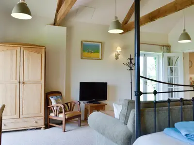 a living room with a bed and a tv at The Studio-Uk11822 in Westleton