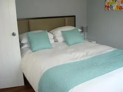 a white bed with two blue pillows on it at Spring Paddocks B&B in Furneux Pelham