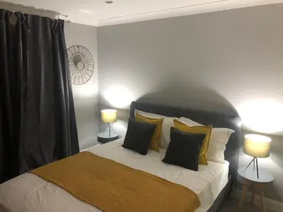 a bedroom with a bed with pillows and two lamps at Adam And Eve Street Apartment in Cambridge