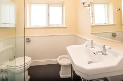a bathroom with a sink and a toilet and a mirror at Willow House in Knodishall, Sleeps 7 - Only a short drive from Aldeburgh, Thorpeness & Snape Maltings - Managed by Aldeburgh Coastal Cottages in Aldringham