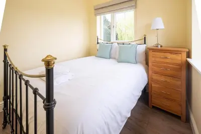 a bedroom with a bed and a window at Willow House in Knodishall, Sleeps 7 - Only a short drive from Aldeburgh, Thorpeness & Snape Maltings - Managed by Aldeburgh Coastal Cottages in Aldringham