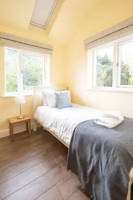 a bedroom with two beds and two windows at Willow House in Knodishall, Sleeps 7 - Only a short drive from Aldeburgh, Thorpeness & Snape Maltings - Managed by Aldeburgh Coastal Cottages in Aldringham