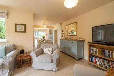 a living room with two chairs and a flat screen tv at Willow House in Knodishall, Sleeps 7 - Only a short drive from Aldeburgh, Thorpeness & Snape Maltings - Managed by Aldeburgh Coastal Cottages in Aldringham