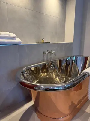 a bath tub in a bathroom with a sink at Poets House in Ely