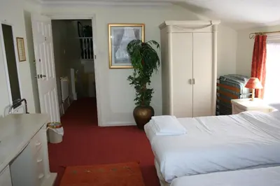 a bedroom with a bed and a plant in it at Hartland 2-Bedroom Apartments with Bfast and Parking in Southend-on-Sea