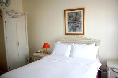 a bedroom with a white bed and a picture on the wall at Hartland 2-Bedroom Apartments with Bfast and Parking in Southend-on-Sea