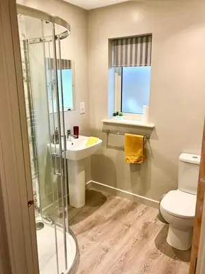 a bathroom with a shower and a toilet and a sink at Waterside Lodges Cambridge in Cambridge