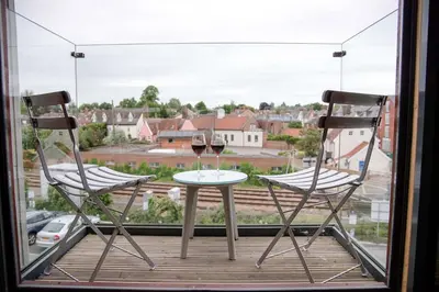 two chairs and a table with two glasses of wine at 8 Deben Wharf, Woodbridge in Woodbridge