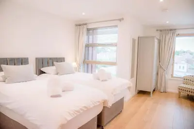 two twin beds in a room with a window at 8 Deben Wharf, Woodbridge in Woodbridge