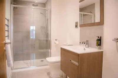 a bathroom with a shower and a toilet and a sink at 8 Deben Wharf, Woodbridge in Woodbridge