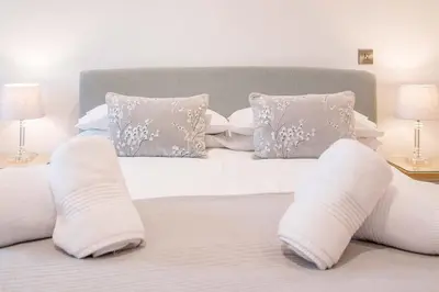 a white bed with white pillows and white sheets at 8 Deben Wharf, Woodbridge in Woodbridge
