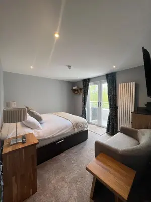 a bedroom with a bed and a couch and a tv at The Three Pickerels in Mepal