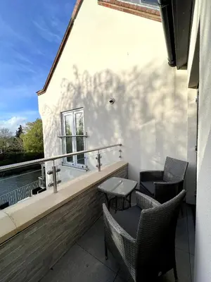 a balcony with chairs and a table and a window at The Three Pickerels in Mepal