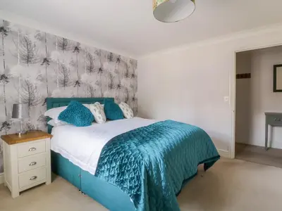 a bedroom with a blue bed with a blue blanket at The Hoist in Ely