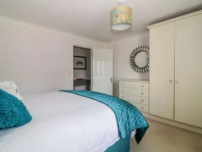 a bedroom with a white bed and a mirror at The Hoist in Ely