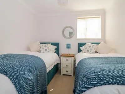 a bedroom with two beds and a mirror on the wall at The Hoist in Ely