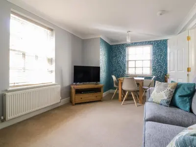 a living room with a couch and a tv and a table at The Hoist in Ely