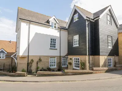 a large black and white house with a fence at The Hoist in Ely