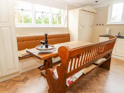 a kitchen with a wooden table and a bench at The Old School in Wereham