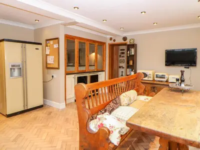 a living room with a table and a refrigerator at The Old School in Wereham