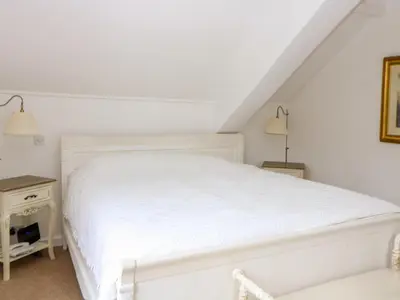 a white bedroom with a white bed and a table at The Old School in Wereham