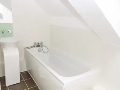 a white bathroom with a tub and a sink at The Old School in Wereham