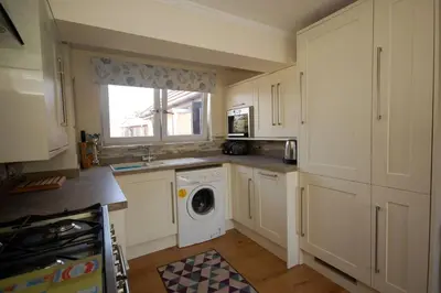 a kitchen with a washing machine and a window at Broxbourne Two-Bedroom Apartment Close To Amenities in Hoddesdon