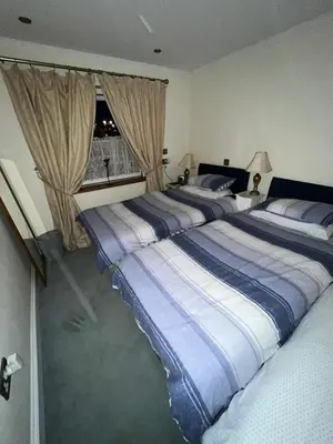 a bedroom with two beds and a window at Broxbourne Two-Bedroom Apartment Close To Amenities in Hoddesdon