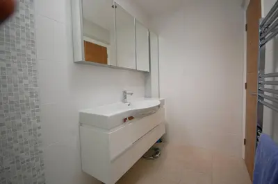a white bathroom with a sink and a mirror at Broxbourne Two-Bedroom Apartment Close To Amenities in Hoddesdon