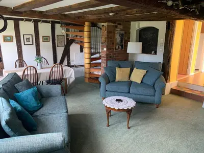 a living room with two blue couches and a table at Beaumont's Cottage in Cambridge