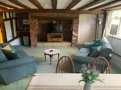 a living room with two blue couches and a fireplace at Beaumont's Cottage in Cambridge