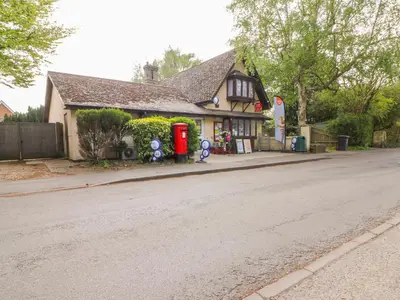 a house with a red phone booth on the side of a street at Beaumont's Cottage in Cambridge