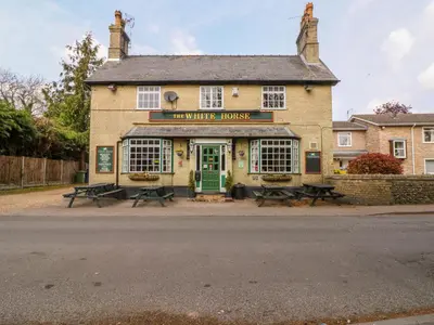 a building with picnic tables in front of it at Beaumont's Cottage in Cambridge