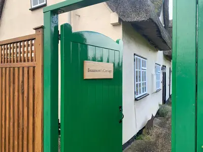 a green door to a house with a sign on it at Beaumont's Cottage in Cambridge