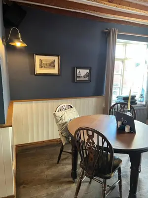a dining room with a wooden table and chairs at The Bell Inn, Rickinghall in Rickinghall