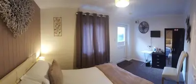 a bedroom with a bed and a desk and a window at Red Lion in Swaffham