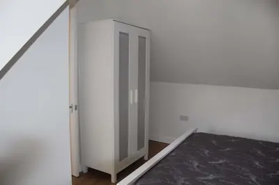 a room with a white closet with a door at The Cart Lodge in Newmarket