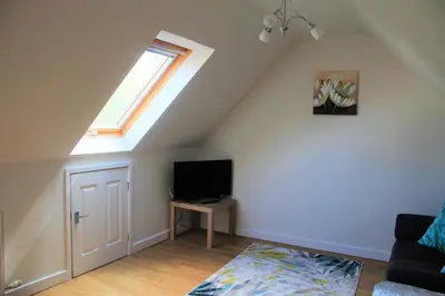 a living room with a tv and a window at The Cart Lodge in Newmarket