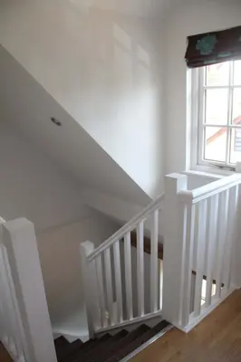 a white staircase with a window and a white railing at The Cart Lodge in Newmarket