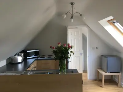 a kitchen with a vase of flowers on a counter at The Cart Lodge in Newmarket
