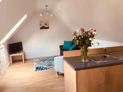 a kitchen with a sink and a vase of flowers on a counter at The Cart Lodge in Newmarket