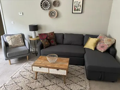 a living room with a black couch and a chair at Old Green Chambers spacious town centre apartment with free parking! in St Ives